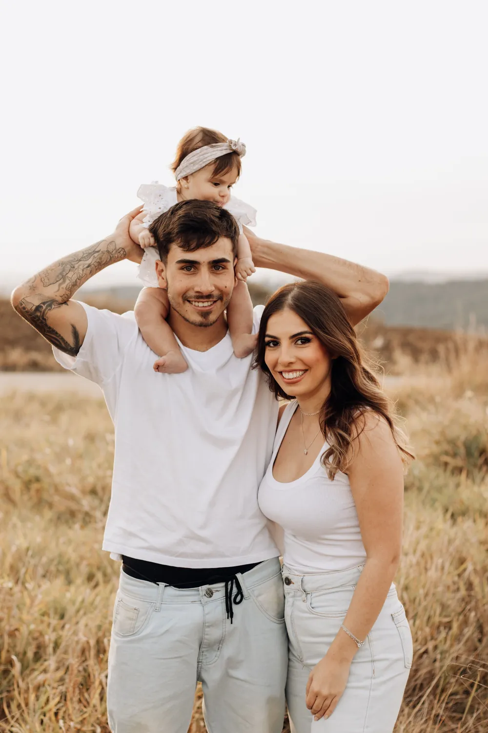 Família passeando ao ar livre com o bebê nos ombros do pai